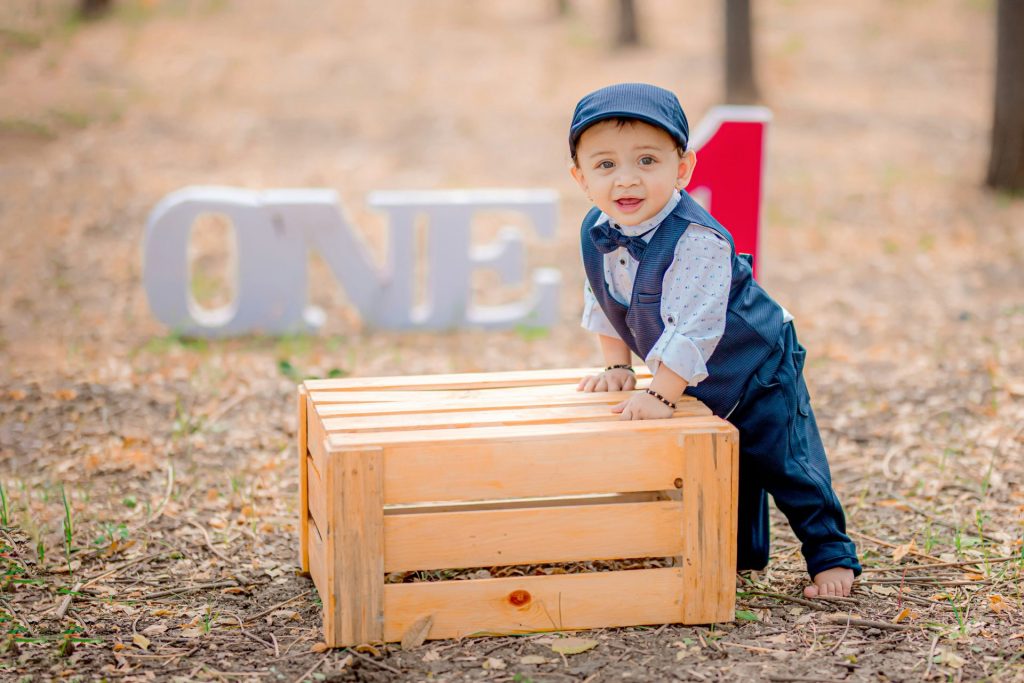 a little boy sitting on top of a wooden box